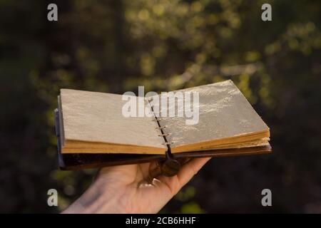 Opened old book with reflected in black surface. Stock Photo
