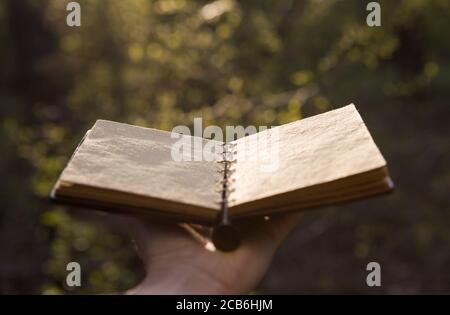 Opened old book with reflected in black surface. Stock Photo