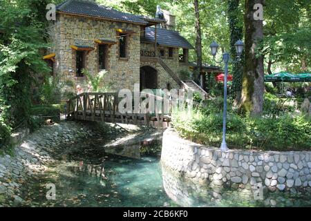 Property with Bridge over landscaped stream in Albania Stock Photo