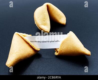 Chinese fortune cookie with message isolated on dark background Stock Photo