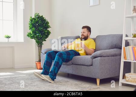 Online communication. Funny guy with beer chatting to friends on laptop from home. Bearded man making video call Stock Photo