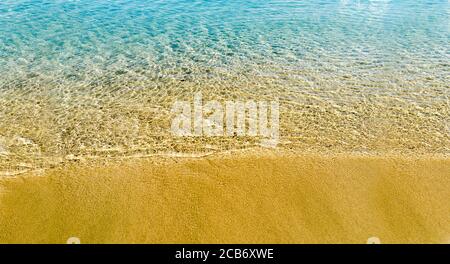 Top view of sea water and sandy beach texture image. Aerial seashore ocean background wallpaper. Tropical sand and coast from above. Stock Photo