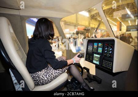 Woman sitting in a cockpit of a passenger helicopter in a pilots seat in front of a dashboard Stock Photo