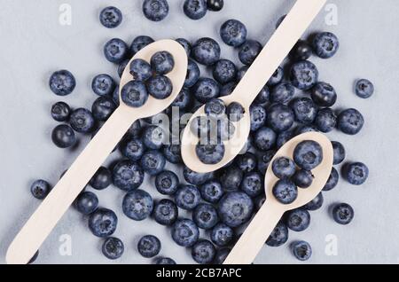 Close up bog bilberries on a wooden spoons. Healthy nutrition concept