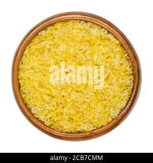 Freshly grated lemon peel in wooden bowl. Zests of ripe yellow edible citrus fruits. Citrus limon. Used as flavoring for baking and cooking. Stock Photo
