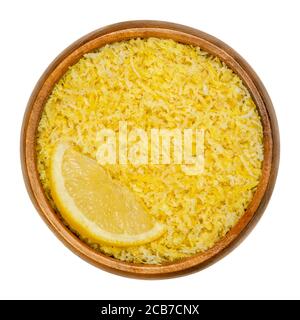 Lemon slice and freshly grated lemon peel in a wooden bowl. Zests of ripe yellow edible citrus fruits. Citrus limon. Used as flavoring for baking. Stock Photo