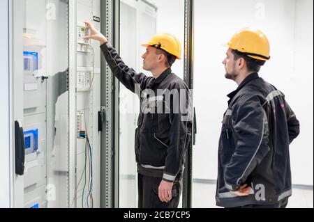 Field service crew testing electronics or inspecting electrical installation system. Bay control unit. Medium voltage switchgear Stock Photo