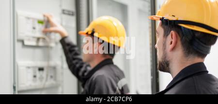 Field service crew testing electronics or inspecting electrical installation system. Bay control unit. Medium voltage switchgear Stock Photo