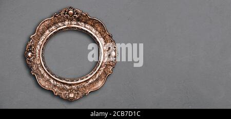 Vintage luxury golden frame with ornate baroque decoration on rustic textured background. Retro fancy picture frame for interior design. Stock Photo