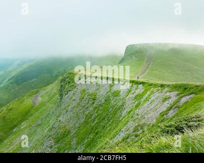 Man walking on green mountain with clouds in Ukraine,Carpathians, Dragobrat Stock Photo