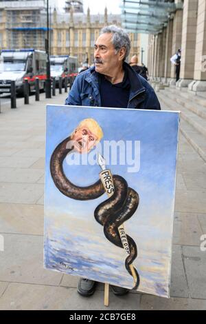 Artist and political satirist painter Kaya Mar with a painting on press freedom during Donald Trump's visit, Westminster, London, UK Stock Photo