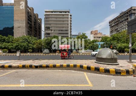 An ice cream vendor rides his cart on an empty street in Connaught Place in New Delhi Stock Photo