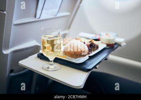 Airline meal and beverage served on seat tables during flight. Stock Photo