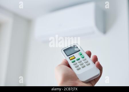 Remote control for air conditioner in hand. Room condition remote control. Air temperature switch for cooling of space. Stock Photo