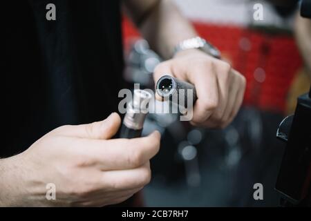 Close-up view of male hands plugging in cables Stock Photo