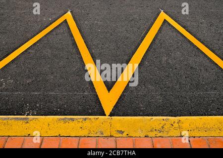 Parking space at a sidewalk marked in yellow reflective paint, an abstract detail. Stock Photo