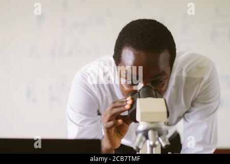African scientist teacher looking microscopes in the laboratory Stock Photo