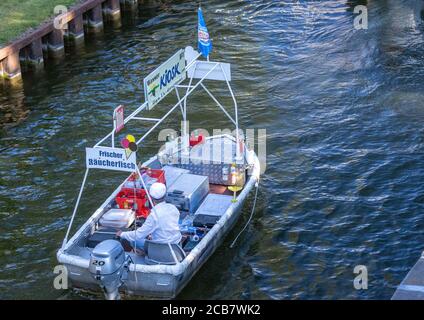 Canow, Germany. 06th Aug, 2020. Jens Winkelmann is on the move with his water kiosk on the Müritz-Havel Canal and supplies holidaymakers on houseboats, yachts and canoes with ice, cold drinks or freshly smoked fish. Every day during the season he is on the waterways and lakes at the state border of Brandenburg and Mecklenburg for up to 80 kilometres. The Brandenburg native has converted his four-metre-long, old barge into a kind of 'floating consumption' with a freezer and and fresh-keeping boxes. Credit: Jens Büttner/dpa-Zentralbild/ZB/dpa/Alamy Live News Stock Photo