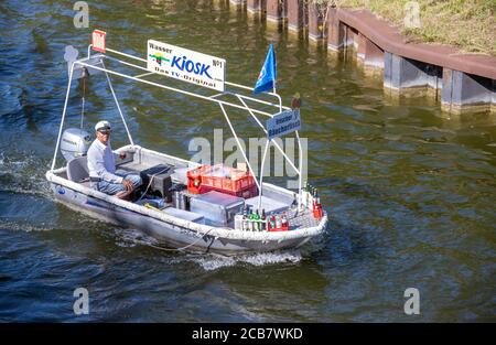 Canow, Germany. 06th Aug, 2020. Jens Winkelmann is on the move with his water kiosk on the Müritz-Havel Canal and supplies holidaymakers on houseboats, yachts and canoes with ice, cold drinks or freshly smoked fish. Every day during the season he is on the waterways and lake at the state border of Brandenburg and Mecklenburg for up to 80 kilometres. The Brandenburg native has converted his four-metre-long, old barge into a kind of 'floating consumption' with a freezer and and fresh-keeping boxes. Credit: Jens Büttner/dpa-Zentralbild/ZB/dpa/Alamy Live News Stock Photo