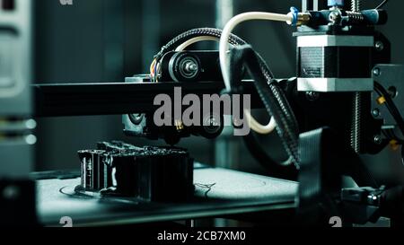 3D printer working in a factory printing plastic part. Stock Photo
