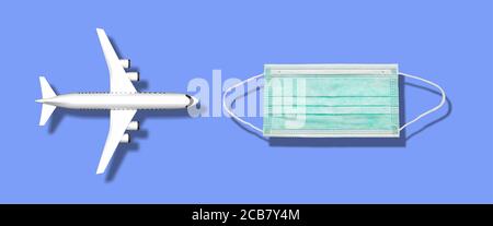 Plane and a protective face mask on blue background. Airplane flight safe, protection against coronavirus, new normal concept. 3d illustration Stock Photo