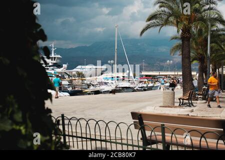 Supetar, Croatia August 2020 Cold moody image of the riviera in Supetar. People walking by on a summer day, rainy clouds in the port Stock Photo