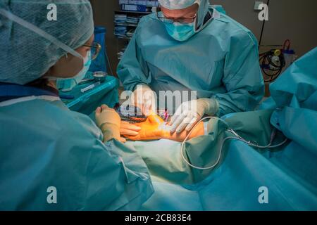 two doctors operate on a wrist fracture in an operating theatre Stock Photo