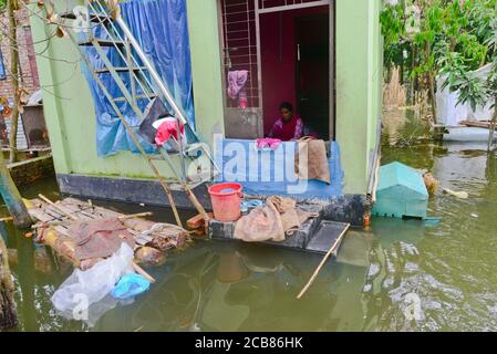 Villager sits in his house seen surrounded by the flood water in Savar near Dhaka, Bangladesh, on August 10, 2020 Stock Photo