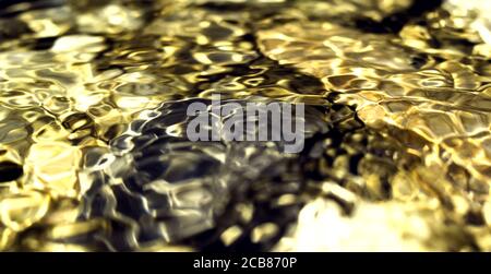 Golden reflections on the water surface, smooth gold and dark background with circular patterns. Perfect background image. Stones on the backdrop Stock Photo