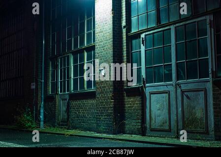 An industrial facade with old doors at night, old gates with glass, an industrial facade aat night Stock Photo