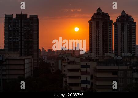 Mumbai, Maharashtra, India - March 2020: The sun setting behind the tall skyscrapers of the suburb of Kandivali East in Mumbai. Stock Photo