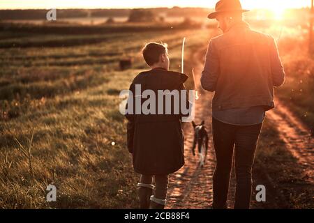 They took fishing rods and gear and go evening fishing by lake. Sunset. Stock Photo