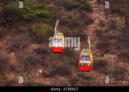 A ropeway trolley is carrying the devotees of Goddess Mansapurna Karni Mata in Udaipur from one end to another - Udaipur, Rajasthan, India Stock Photo