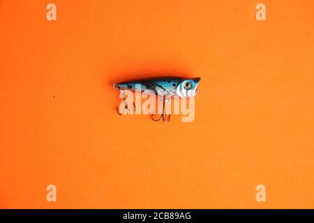 Closeup shot of a fishing hook isolated on an orange background Stock Photo