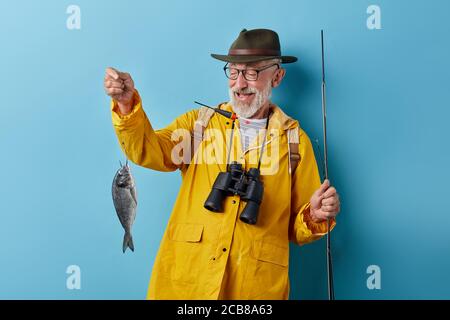 pleasant good looking fishman gets pleasure from fishing process. man relaxing outdoors, helath care, sport Stock Photo
