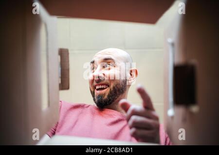 The man points his finger in surprise inside the parcel. Bottom view. Concept of delivery and shipping. Stock Photo
