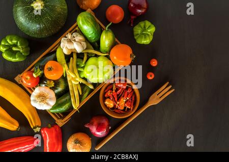 fresh vegetables a top view of ripe vegetables. Different types of fresh vegetables on a black wooden board. Preparation of vegetarian food. Stock Photo