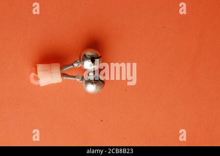 Closeup shot of a fishing hook isolated on an orange background Stock Photo