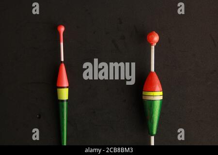 Top view of two colorful fishing rod bobbers on a black background Stock Photo
