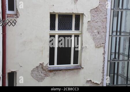 On a street called Klimentska in Prague, you can see some buildings in a state of disrepair, with broken parts of exterior walls, exposing bricks. Stock Photo