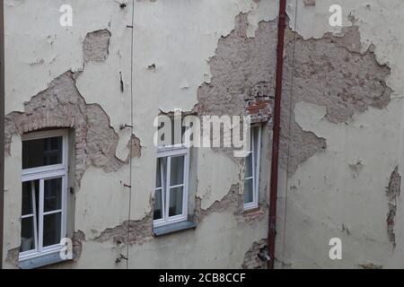 On a street called Klimentska in Prague, you can see some buildings in a state of disrepair, with broken parts of exterior walls, exposing bricks. Stock Photo