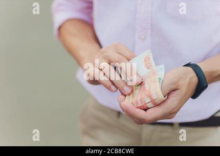 A close up photo of a Caucasian male hand holding a 100 Russian ruble note. Stock Photo