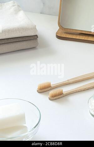 Zero waste concept. Set of eco friendly bathroom accessories - bamboo toothbrushes, cotton buds, natural hairbrush, mirror and linen napkines. Sustainable lifestyle. Stock Photo