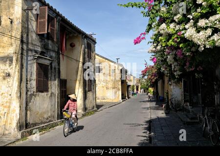Woman on bicycle in Hoi An old town, Vietnam Stock Photo