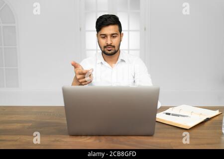 Young Asian Indian businessman working on laptop in modern office Stock Photo