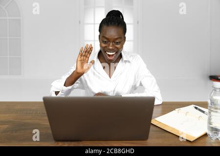 Corporate communication. Black businesswoman talking on web cam laptop in modern office. Free space Stock Photo