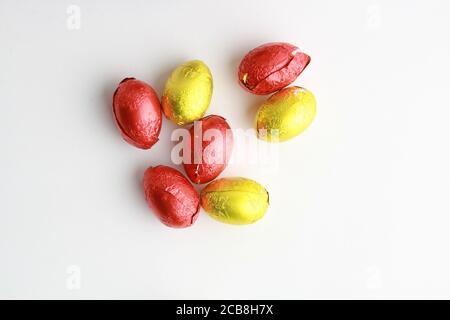 Closeup of chocolate Easter egg candies wrapped in yellow and red paper Stock Photo