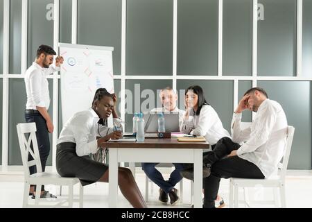 Business, teamwork, people and crisis concept - business team sitting sad and solving problem in office Stock Photo