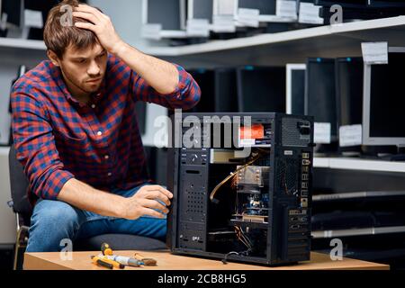 unhappy pensive man looking confused repairing hardware. close up portrait. copy space Stock Photo