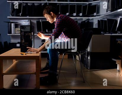 handsome technician concentrated on his work, close up side view photo. man takes up computer repair business Stock Photo